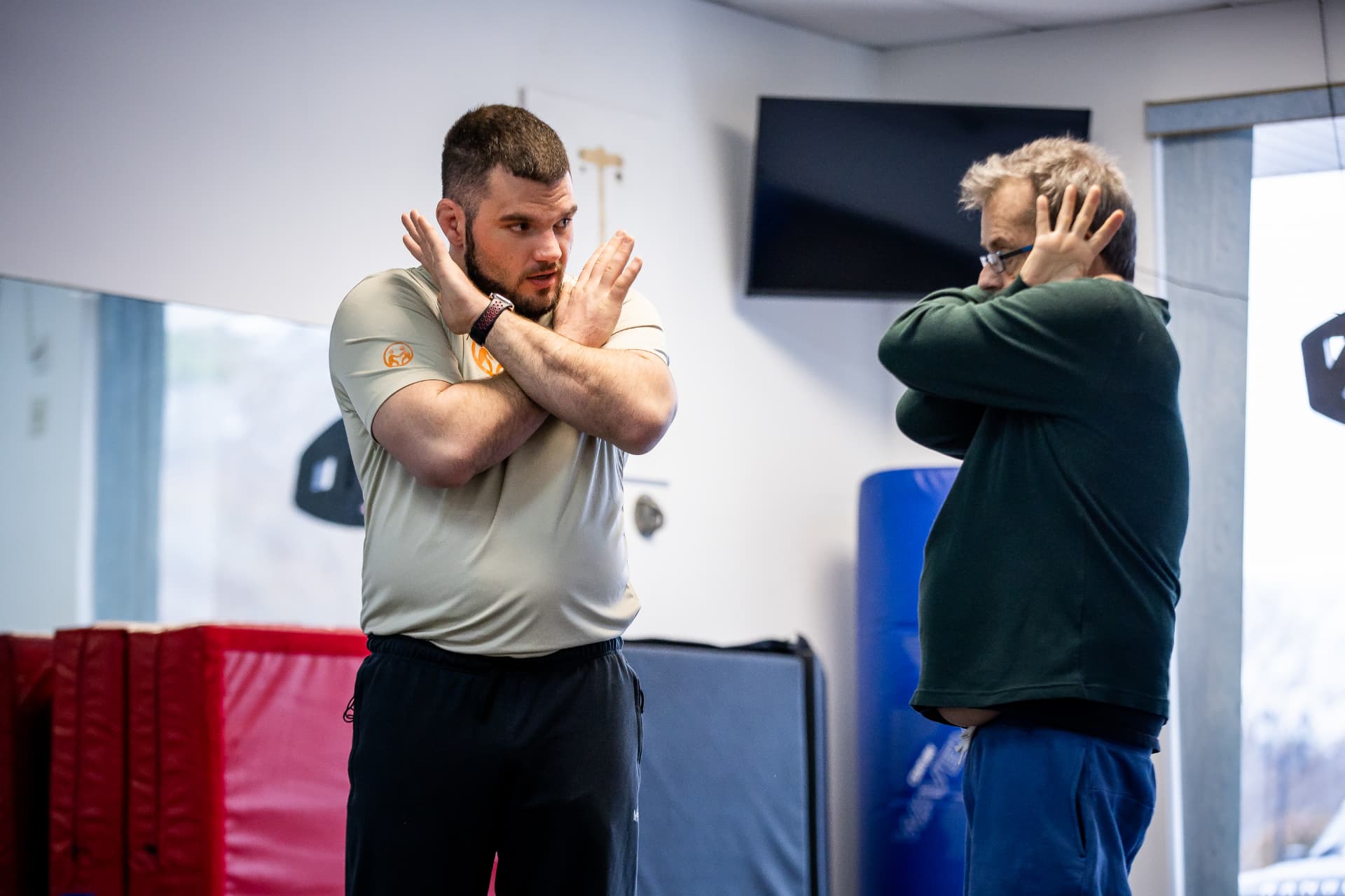 Bryan demonstrating a crossed-arm protective guard for an adult participant