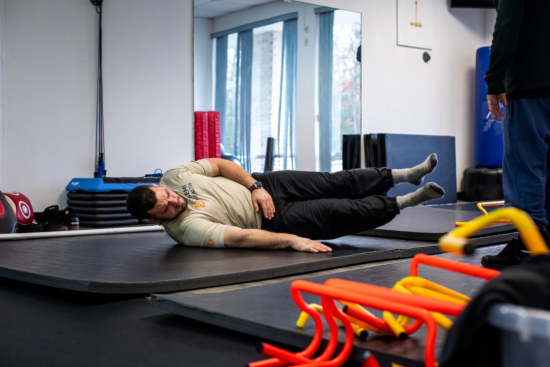 Bryan demonstrating a controlled side-fall position on a training mat